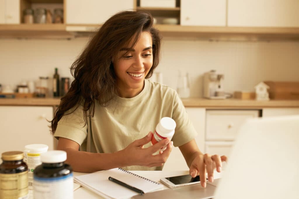 Mulher com suplemento na mão para substituir os alimentos ricos em vitamina b12