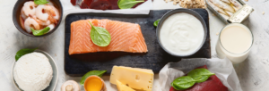 mesa com diversos alimentos ricos em vitamina b12, como queijos, peixe e outros