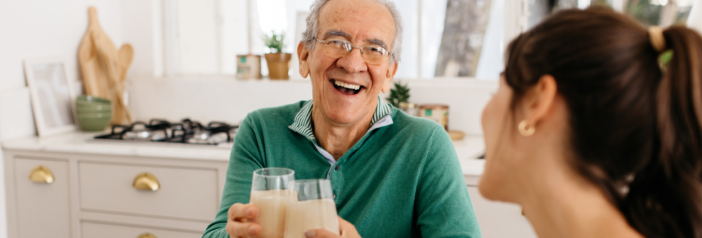 homem idoso sorrindo segurando suplemento em pó whey protein cleanpro