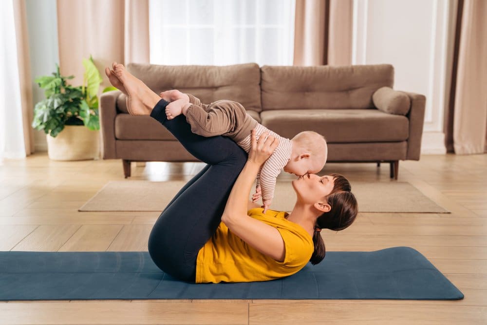 Mulher com o bebê demonstrando que musculação na gravidez auxilia no pós parto